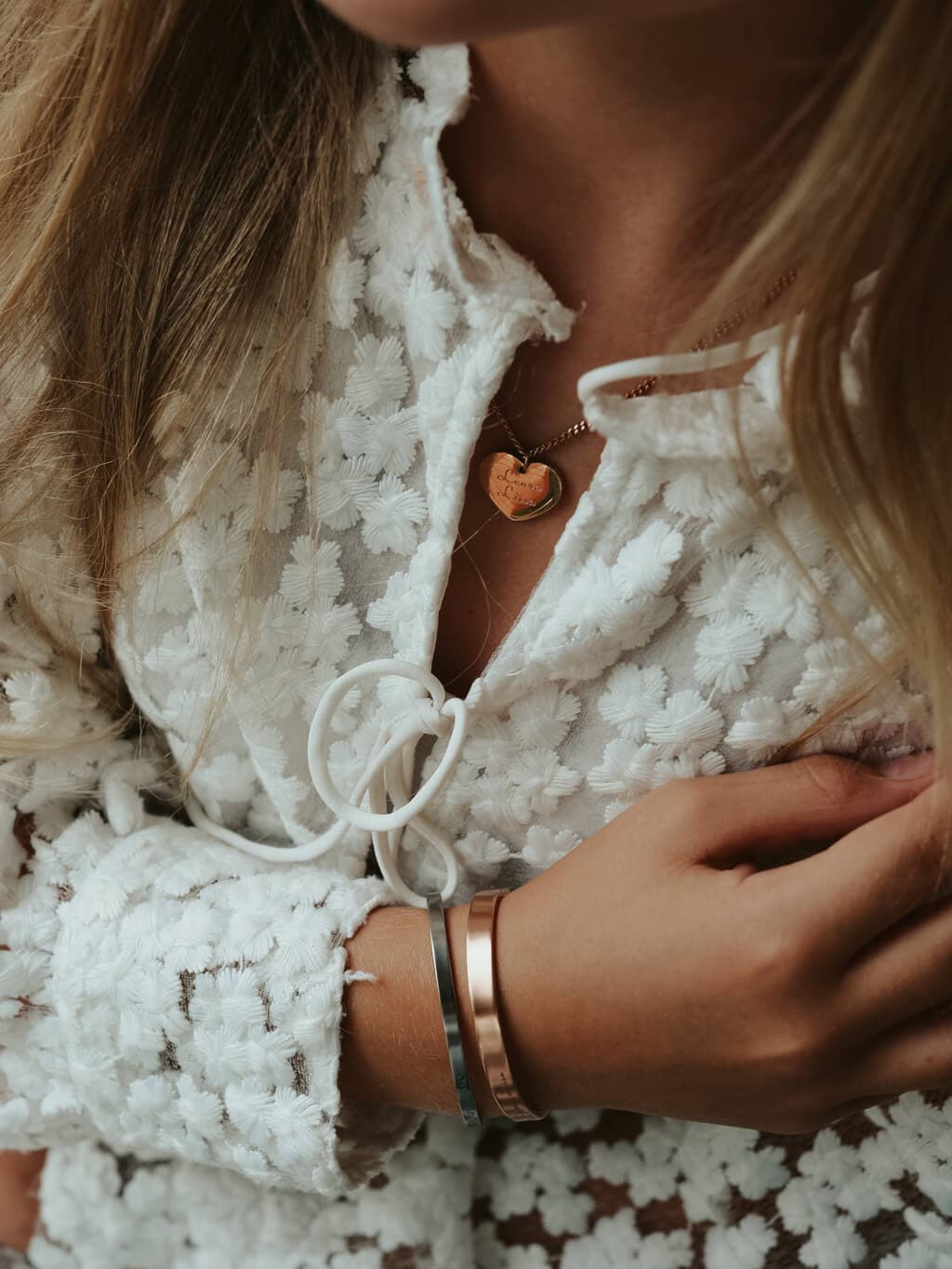 Image that has a pretty girl sitting by water showing bracelet